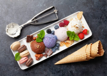 Berry, vanilla and chocolate ice cream sundae and macaroon sweets. Top view flat lay