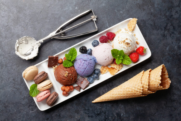 Berry, vanilla and chocolate ice cream sundae and macaroon sweets. Top view flat lay