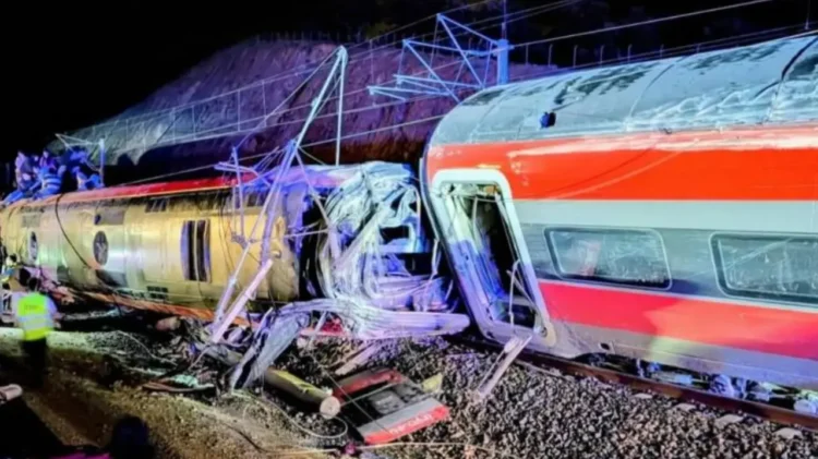 Due treni ad alta velocità deragliati e gravemente danneggiati dopo un violento scontro notturno in Andalusia, Spagna, con vagoni accartocciati e soccorritori sul luogo dell’incidente.