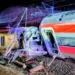 Due treni ad alta velocità deragliati e gravemente danneggiati dopo un violento scontro notturno in Andalusia, Spagna, con vagoni accartocciati e soccorritori sul luogo dell’incidente.